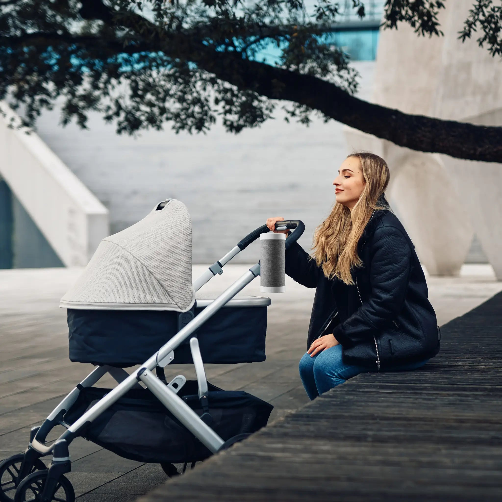 A mother using RockingRide attached to a stroller while enjoying a peaceful moment outdoors.