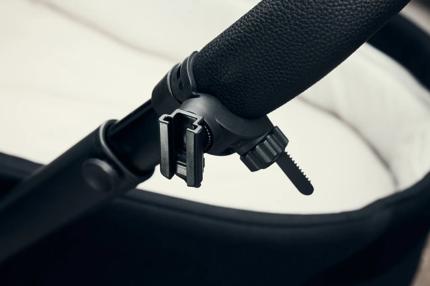 Close-up of the RockingRide® mounting bracket securely attached to a stroller handle, highlighting its sturdy and adjustable design.