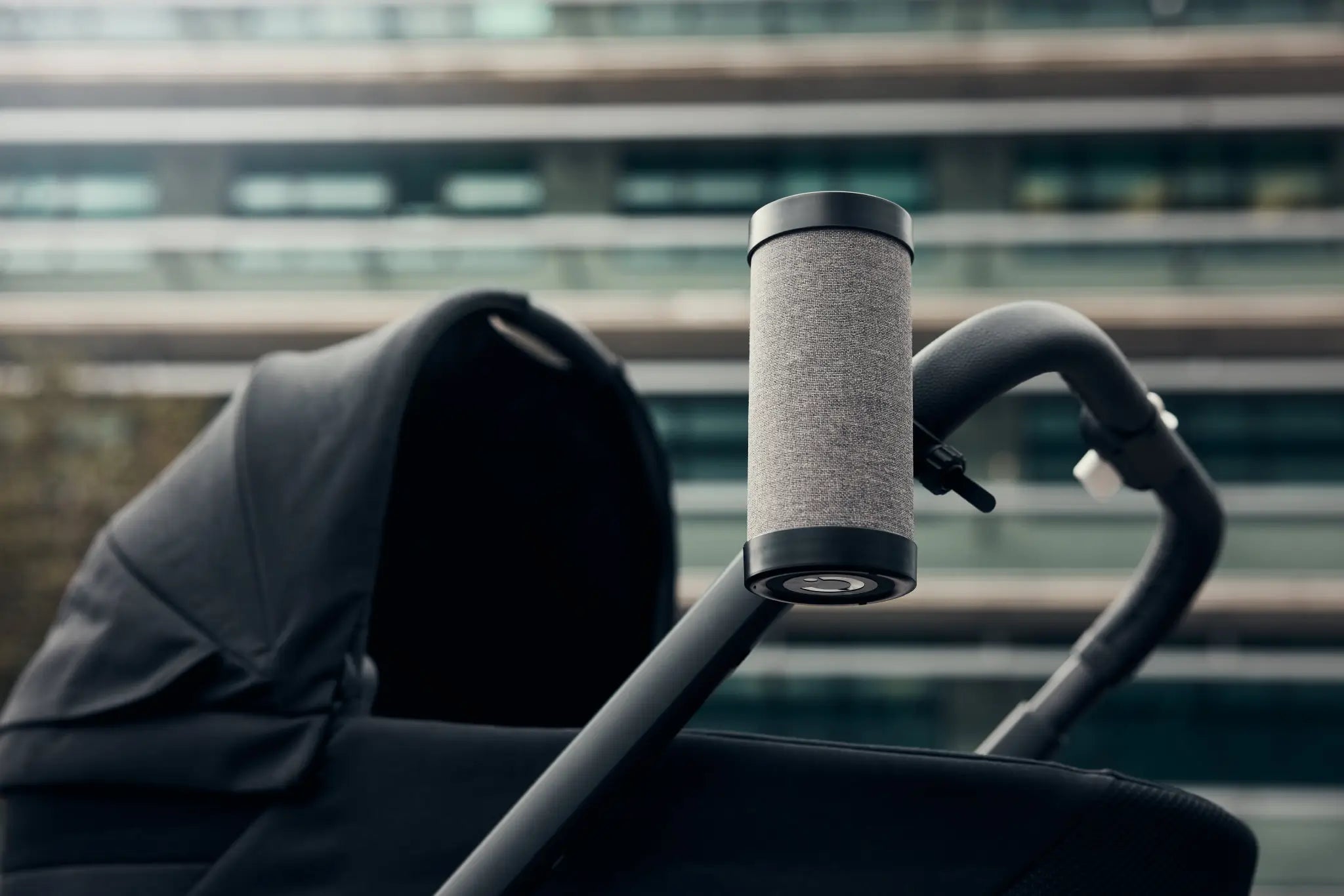 Close-up of the RockingRide stroller rocker in black, securely attached to a stroller handle. The image highlights the sleek and modern design, making it an ideal solution for hands-free rocking during walks with your baby.