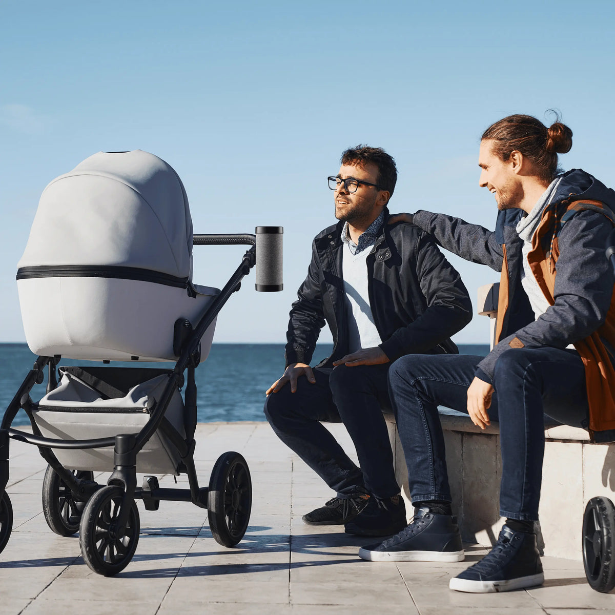 Parents relaxing while baby stroller gently rocks with RockingRide automatic stroller rocker
