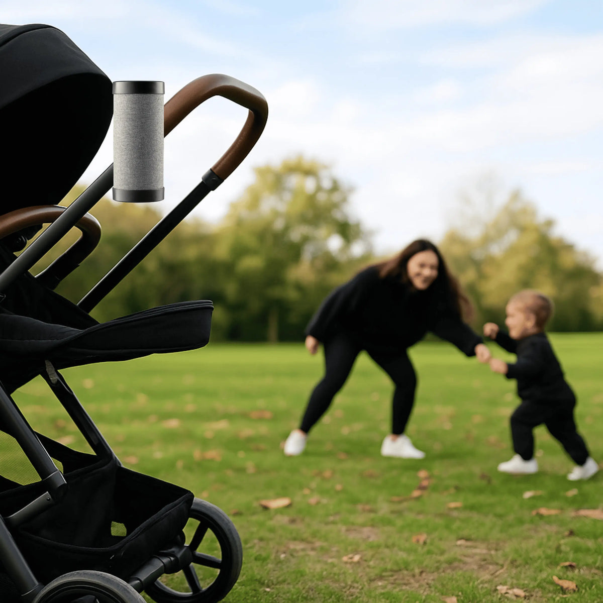 Baby stroller with RockingRide automatic rocker in park while parent and child play in background